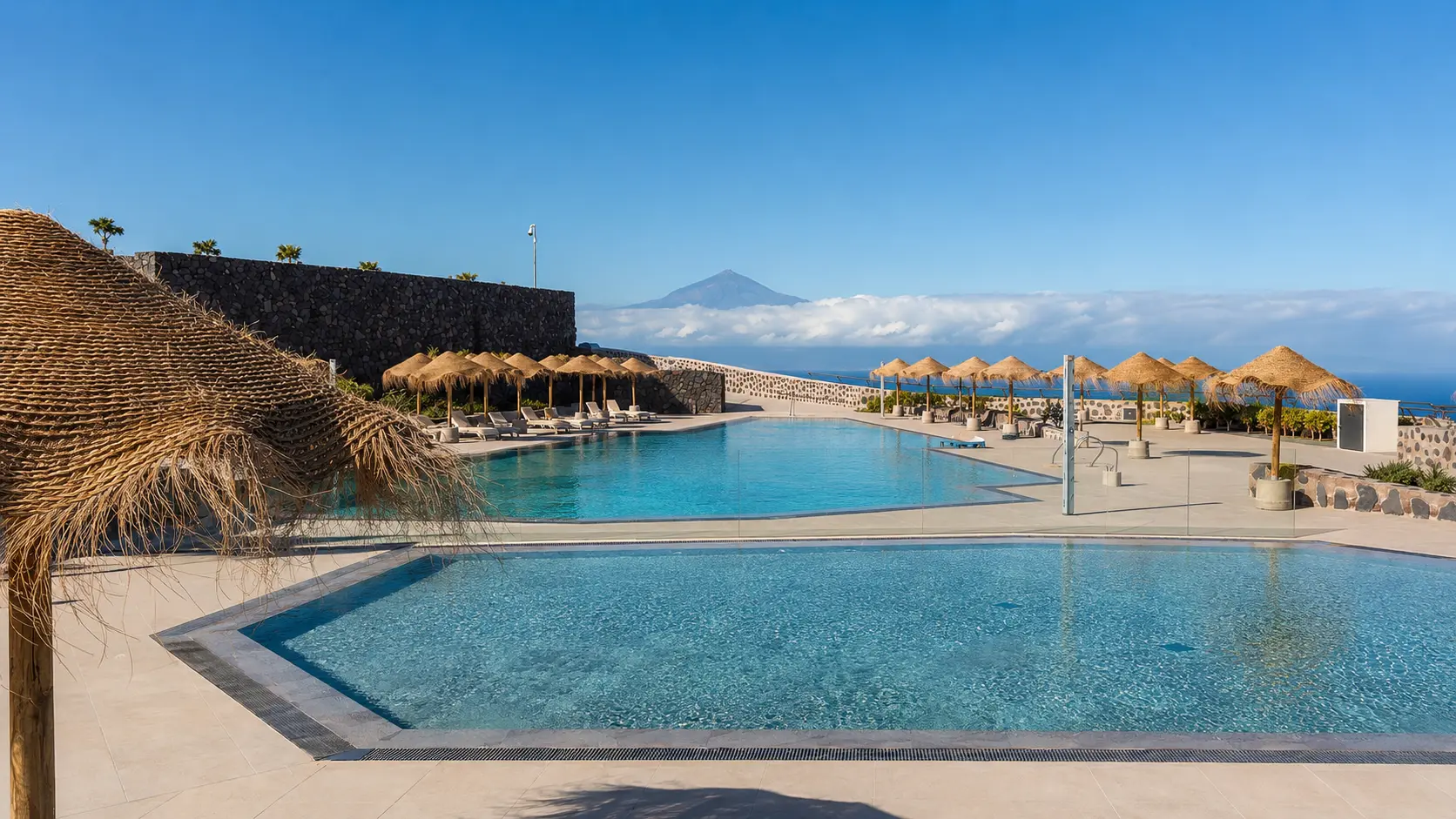 Piscina exterior del hotel orientada hacia el océano y la silueta del Teide