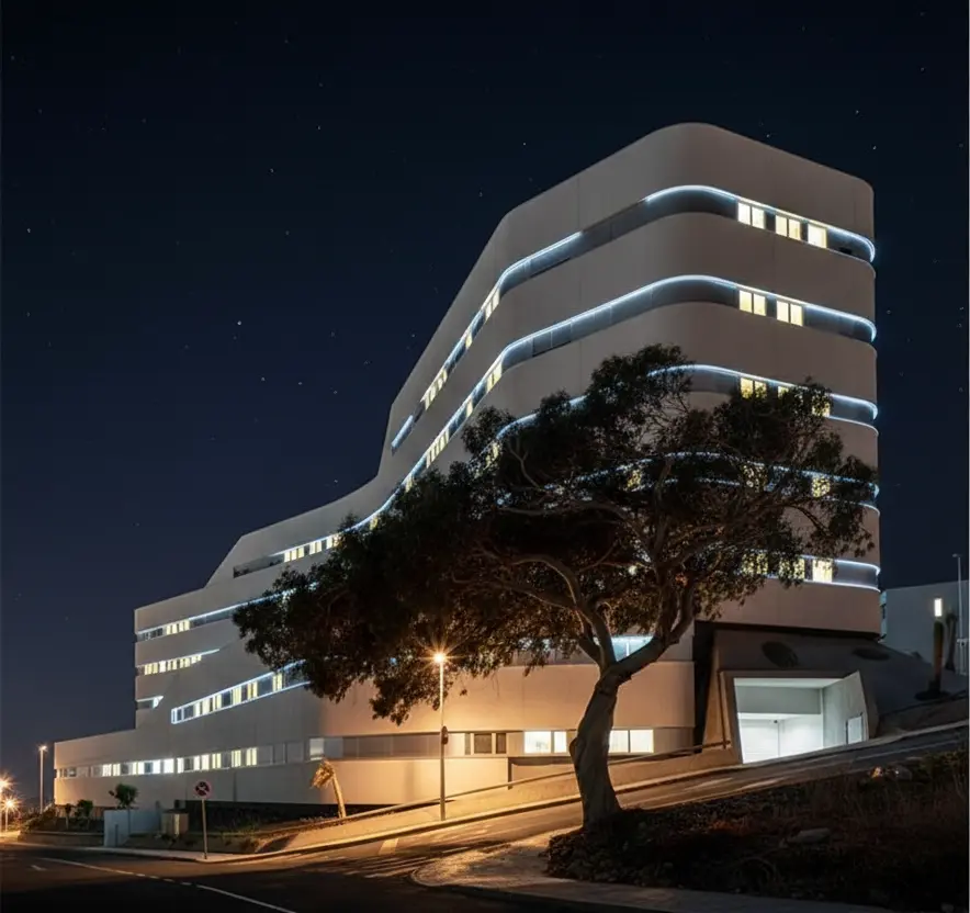 Vista nocturna del acceso y del desarrollo del edificio sobre la pendiente