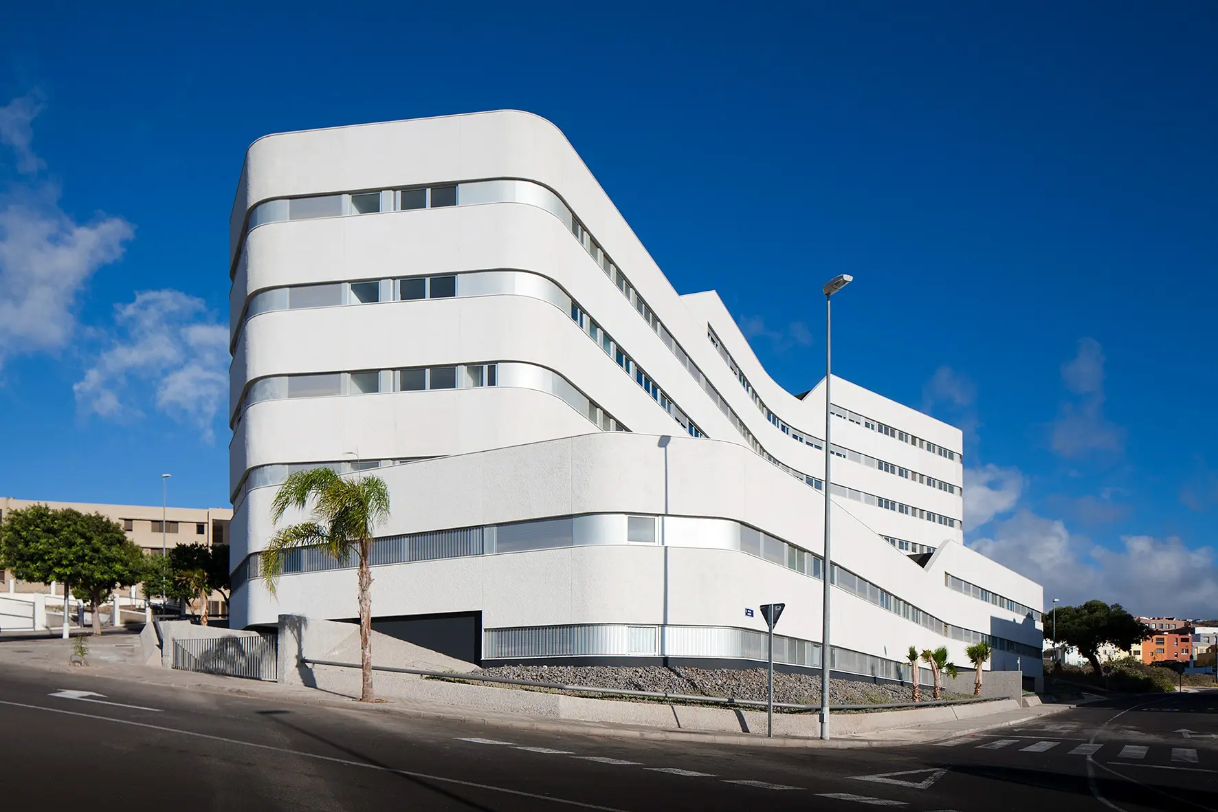 Fachada curva del edificio de 64 viviendas y garajes en La Gallega