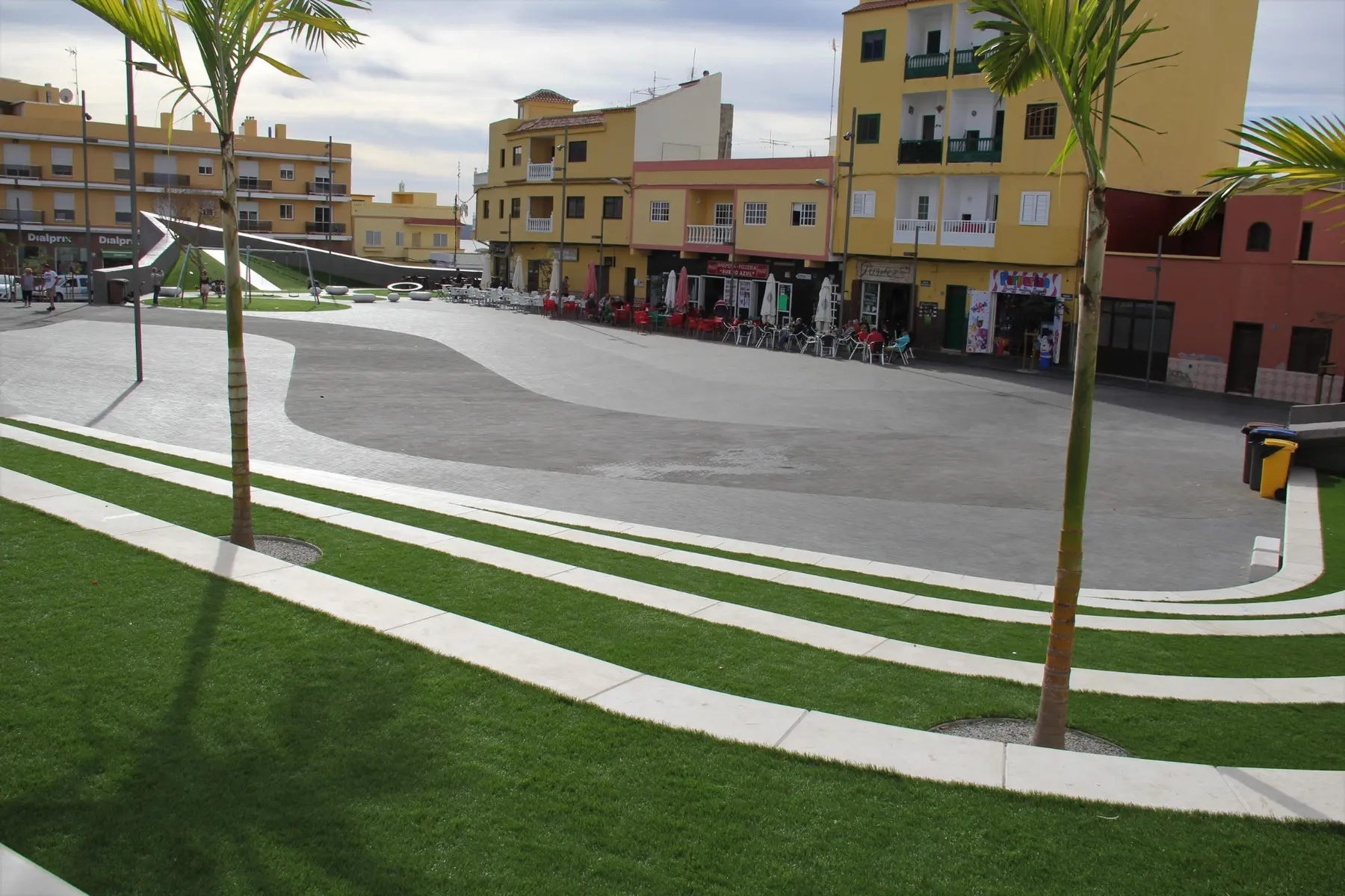 Vista general de la Plaza de Playa San Juan con el espacio central, las gradas verdes y las palmeras